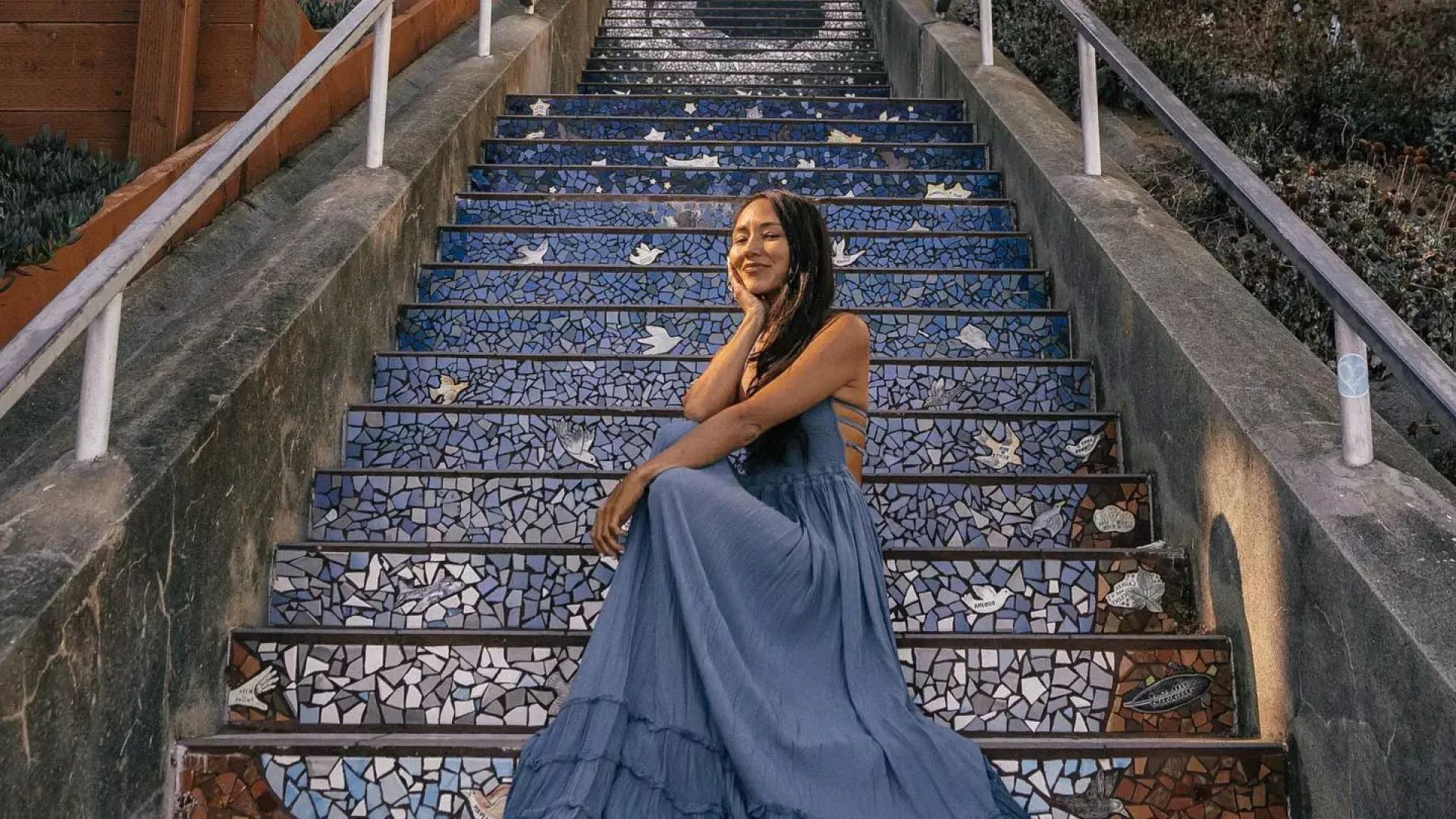 Una mujer posa sentada en las escaleras de azulejos de la Avenida 16 en el barrio Sunset de San Francisco.